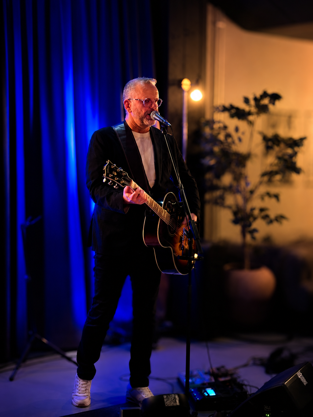 Trubaduren Henke spelar gitarr på scen